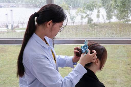 中场景,俱乐部负责人为成员佩戴发簪